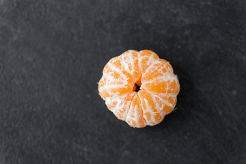 Image showing close up of peeled mandarin on slate table top