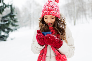 Image showing happy young woman with tea cup in winter park