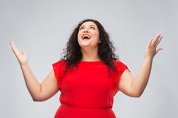 Image showing happy smiling woman in red dress looking up