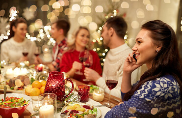 Image showing woman calling on smartphone at christmas dinner