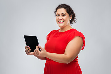 Image showing happy woman in red dress using tablet computer