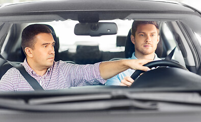 Image showing car driving school instructor teaching male driver