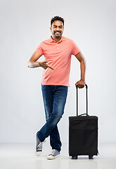 Image showing smiling indian man in polo shirt with travel bag