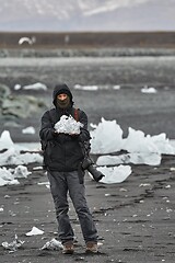 Image showing Photographer picking up pieces of icebergs