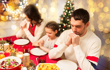 Image showing family praying before meal at christmas dinner