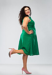 Image showing happy woman in green dress over grey background