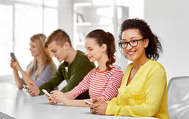 Image showing happy high school students with smartphones