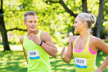 Image showing happy couple of sportsmen racing wit badge numbers