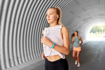 Image showing women or female friends with earphones running