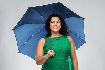 Image showing happy woman in green dress with blue umbrella