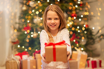 Image showing smiling girl with christmas gift at home