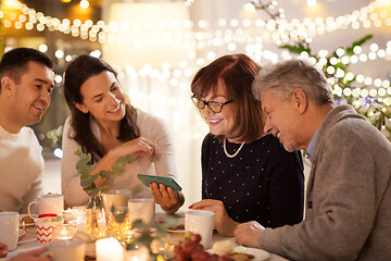 Image showing happy family with smartphone at tea party at home