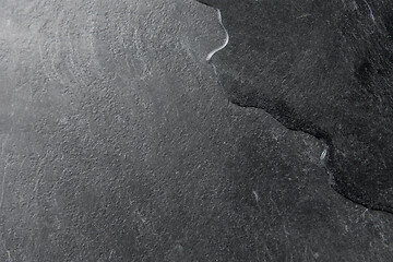 Image showing spilled water on black slate stone background