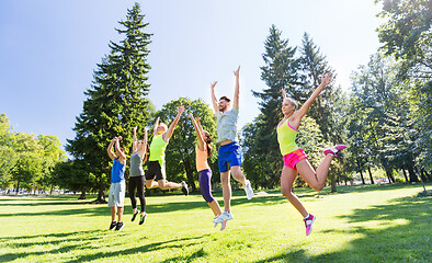 Image showing group of happy friends jumping high at park