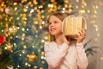 Image showing smiling girl with christmas gift at home