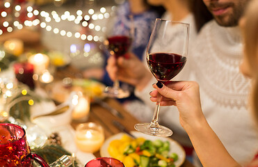 Image showing close up of friends drinking red wine on christmas