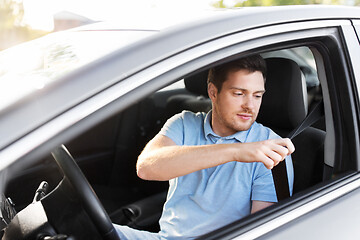 Image showing man or car driver fastening seat belt