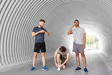 Image showing male friends with earphones training outdoors