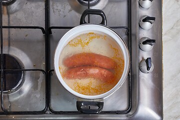 Image showing Boiling sausages on stove