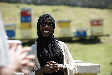 Image showing woman giving presentation to group of business investors on local honey production farm