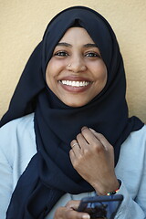 Image showing african woman using smartphone wearing traditional islamic clothes