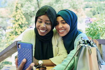 Image showing african female friends using smart phone together