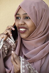 Image showing african woman using smartphone wearing traditional islamic clothes