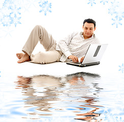 Image showing relaxed man with laptop on white sand