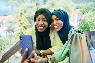 Image showing african female friends using smart phone together