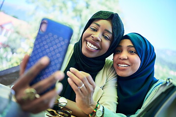 Image showing african female friends using smart phone together