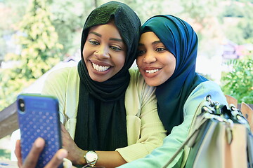 Image showing african female friends using smart phone together