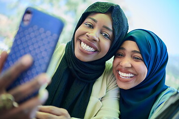 Image showing african female friends using smart phone together