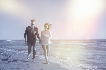 Image showing Loving young couple on a beach at autumn sunny day