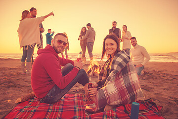 Image showing Couple enjoying with friends at sunset on the beach