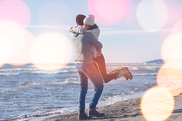 Image showing Loving young couple on a beach at autumn sunny day