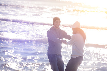 Image showing Loving young couple on a beach at autumn sunny day