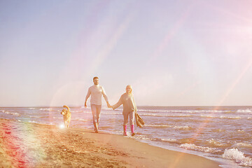 Image showing couple with dog having fun on beach on autmun day