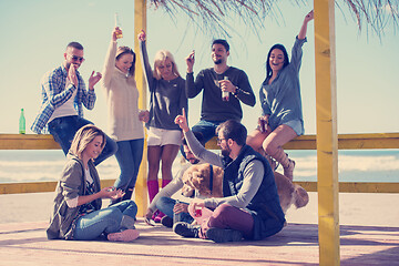 Image showing Group of friends having fun on autumn day at beach