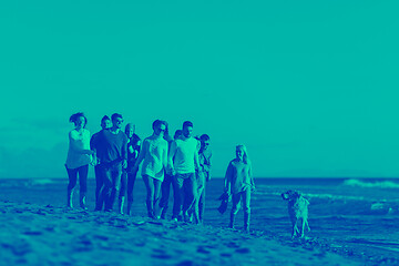 Image showing Group of friends running on beach during autumn day