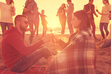 Image showing Couple enjoying with friends at sunset on the beach