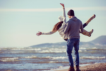 Image showing Loving young couple on a beach at autumn sunny day