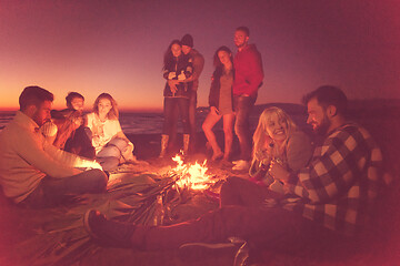 Image showing Couple enjoying with friends at sunset on the beach