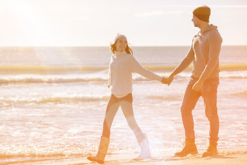 Image showing Loving young couple on a beach at autumn sunny day