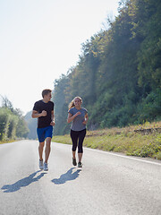 Image showing young couple jogging along a country road