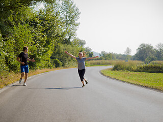 Image showing young couple jogging along a country road