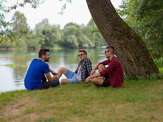 Image showing men sitting on the bank of the river