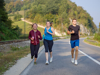 Image showing young people jogging on country road