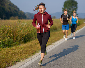 Image showing young people jogging on country road