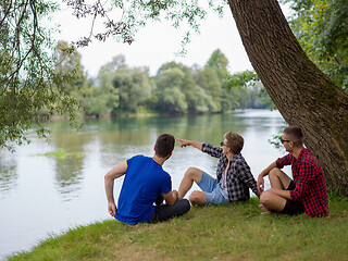 Image showing men sitting on the bank of the river