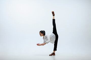 Image showing Woman working at office and jumping isolated on studio background